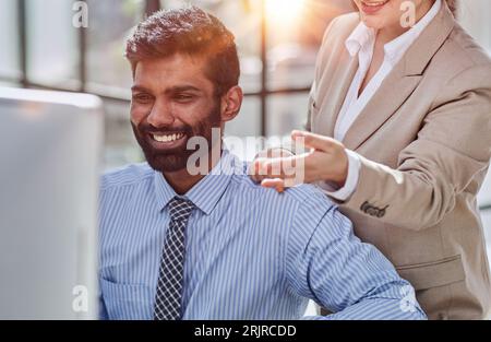 Lavorare insieme sul progetto. Due giovani colleghi di lavoro che lavorano sul computer Foto Stock