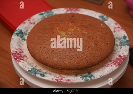 Una torta di prugne rotonde appena sfornata su un piatto, decorata con elementi festivi per festeggiare il Natale Foto Stock