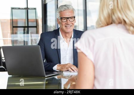 Imprenditore snd donna seduta in ufficio, discutendo di progetto Foto Stock