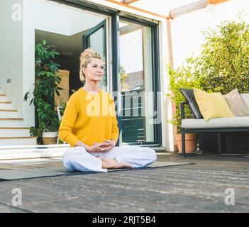 Ritratto di donna matura meditando sulla terrazza Foto Stock