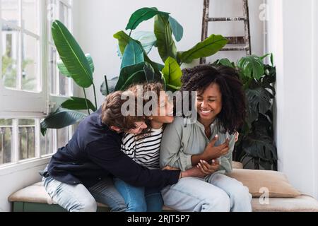 Una famiglia felice seduta nel giardino d'inverno che ride e si diverte Foto Stock