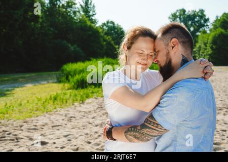 Uomo romantico che abbraccia una donna incinta sul campo Foto Stock