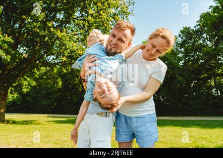 Figlio giocoso che si diverte con i genitori sul campo Foto Stock
