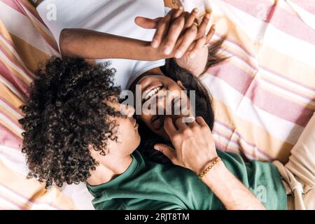 Coppia amorevole che si tiene per mano stesa su una coperta Foto Stock