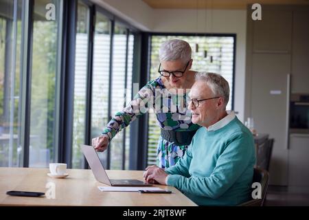 Coppia anziana che usa il notebook a casa Foto Stock