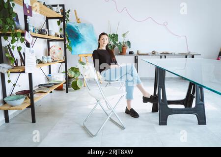 Artista seduto sulla sedia del workshop Foto Stock