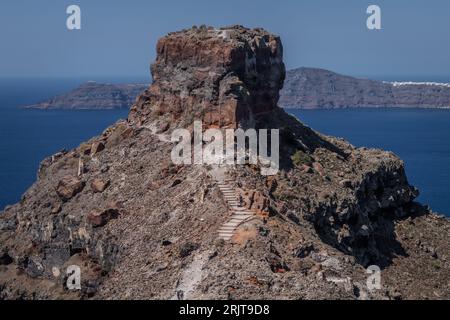 Una vista aerea dell'isola tropicale di Santorini, Grecia, caratterizzata da una tortuosa scalinata in pietra che conduce alla cima di una montagna torreggiante Foto Stock