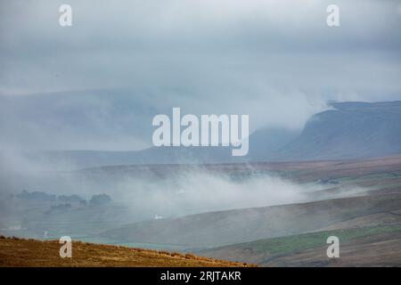 Guardando in basso verso Widdybank Fell e la valle di Harwood Beck vicino al fiume Tees, Upper Teesdale, County Durham, con nebbia e nebbia sulle colline Foto Stock