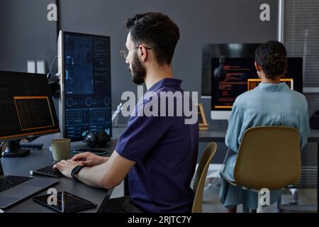 Programmatori di computer che lavorano su PC desktop in ufficio Foto Stock