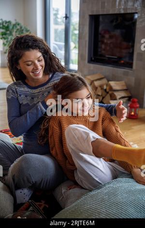 Madre e figlia felici che si divertono a Natale a casa Foto Stock