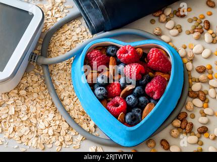 Heart shaped bowl with berries and nuts, close up. Stock Photo