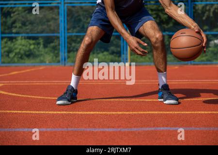 Gambe muscolari di un allenamento irriconoscibile per giocatori di basket in campo all'aperto. Foto Stock