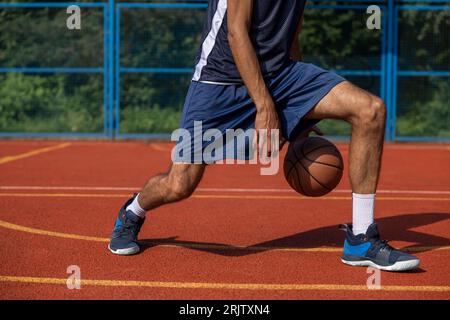 Gambe muscolari di un allenamento irriconoscibile per giocatori di basket in campo all'aperto. Foto Stock