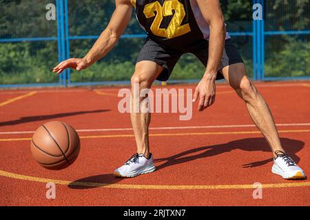 Gambe muscolari di un allenamento irriconoscibile per giocatori di basket in campo all'aperto. Foto Stock