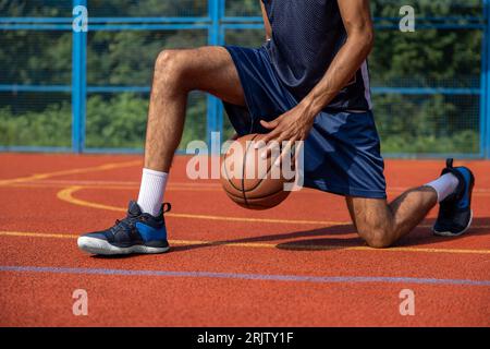 Gambe muscolari di un allenamento irriconoscibile per giocatori di basket in campo all'aperto. Foto Stock