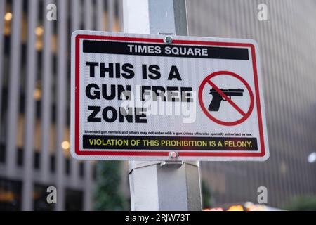 New York, New York, USA. 22 agosto 2023. Un cartello proibizionista di armi all'ingresso di Times Square. La polizia di New York ha installato questi cartelli dopo che le rigide leggi sulle armi di New York sono state abbattute dalla Corte Suprema, citando le violazioni costituzionali del secondo emendamento condotte dalle autorità di New York nel processo di autorizzazione delle armi. Times Square è una popolare destinazione turistica ed è sede della cerimonia di lancio del pallone di Capodanno, ma è infamamente evitato dalla gente del posto perché è una trappola turistica. Diverse società con uffici a Times Square includono Reuters, ABC News, Morgan Stanley e Barclays. (Merito i Foto Stock