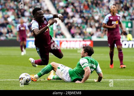 Lewis Stevenson dell'Hibernian (a destra) fa cadere Moussa Diaby dell'Aston Villa per un calcio di rigore durante la prima tappa della partita di play-off della UEFA Europa Conference League a Easter Road, Edimburgo. Data foto: Mercoledì 23 agosto 2023. Foto Stock