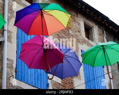 Ombrelloni colorati in strada a Puy l'Eveque Foto Stock