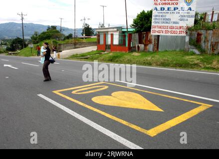 Bildnummer: 52058460 Datum: 16.07.2007 Copyright: imago/Xinhua Mutter trägt ihr Baby über eine Straße mit einer Herz-Markierung in einem Außenbezirk von San Jose (Cile) - Die Markierung gedenkt einem Verkehrsopfer und mahnt zum vorsichtigeren Fahren, um weiterer Verkehrsunfälle zu verhindern - PUBLICATIONxNOTxen, San Jose, 2007, San Jose, CHINXN; Fußgänger, Fußgängerin, überqueren, Überquerung, passante, Passanten, Mutter, Eltern, Kind, Kinder, Frau, Baby, Babys, Straßenmarkierung, Straßenmarkierungen, Markierungen, Markierung, Fahrbahnmarkierung, Piktogramm, Piktogram, Herz, Herz Foto Stock