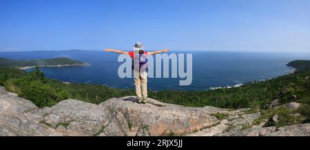 Young hiker standing on the rock and enjoying the landscape in Acadia National Park, Maine, USA Stock Photo