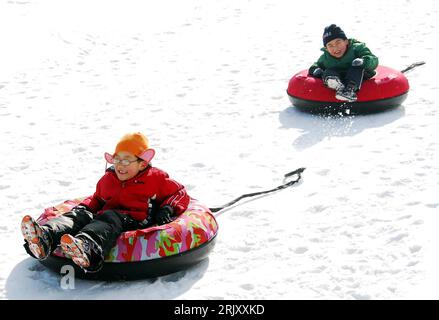 Bildnummer: 52373287 Datum: 31.01.2008 Copyright: imago/Xinhua Zwei Jungen fahren auf Gummireifen einen Schneehang herunter im Skigebiet Yantai in der chinesischen Provinz Shandong - PUBLICATIONxNOTxINxCHN , Objekte , Personen , Optimistisch; 2008, Cina, Schnee, Wintersport, Reifen, Schlittenfahren, Skigebiet, Wintersportgebiet, Kind, Kinder, Freizeit; , quer, Kbdig, Winter, Jahreszeit, Gruppenbild, , Asien o0 rodeln, rodelt Foto Stock