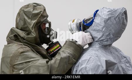 PRODUCTION - 23 August 2023, Lower Saxony, Dethlingen: Workers check their protective extractions during a demonstration. Chemical weapons originating from the Wehrmacht are now to be recovered from the Dethlingen pond. The pond was filled in after the Second World War. More than 100,000 different weapons are said to be in the pond, which is ten to twelve meters deep. An investigation of a neighboring groundwater body had revealed massive contamination with explosive ordnance degradation products. During the subsequent reconnaissance of the pond between September 2019 and April 2020 at three p Stock Photo