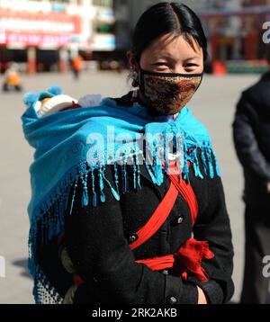 Bildnummer: 53154989 Datum: 17.03.2009 Copyright: imago/Xinhua foto scattata il 2 marzo 2009 mostra un residente tibetano che porta il suo bambino cammina per la strada di Kangding, nella prefettura autonoma tibetana di Garze, nella provincia del Sichuan della Cina sud-occidentale. Reisen kbdig Frau, Kind, Mutter, Land, Leute, Mundschutz quer ie Bildnummer 53154989 Data 17 03 2009 Copyright Imago XINHUA foto scattata IL 2 marzo 2009 mostra un residente tibetano che trasporta il suo bambino cammina SULLA strada di Kangding Garze Prefettura autonoma tibetana nella provincia di Sichuan del sud-ovest della Cina viaggi Kbdig donna bambino Paese madre persone M Foto Stock