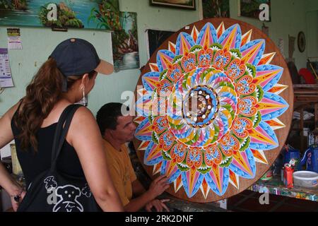 Bildnummer: 53173041 Datum: 24.06.2009 Copyright: imago/Xinhua Un visitatore straniero (1st L) apprezza una ruota di un carro di buoi dipinto da Rolando Alvarado (2nd L) in un laboratorio a Sarchi, Costa Rica, il 23 giugno 2009. La produzione tradizionale di carretto di buoi è una delle tecniche più famose in Costa Rica. I carri di bue svolgono un ruolo importante nella storia dell'agricoltura della Costa Rica, in quanto un tempo erano i principali veicoli per la tranazione dei chicchi di caffè. Ora è diventato un simbolo della vita rurale in Costa Rica. Kbdig Aussenansichten einer Foreign Visitor (1° L) apprezza einer Rad di Ausgedient oxcart bemalt Foto Stock