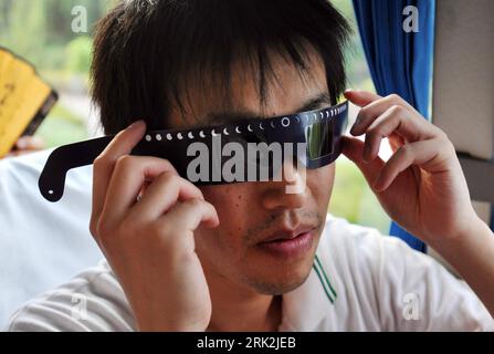 Bildnummer: 53211845  Datum: 18.07.2009  Copyright: imago/Xinhua (090719) -- WUHAN, July 19, 2009 (Xinhua) -- A resident of Japanese city of Oita shows his solar eclipse observing spectacle as he arrives in Wuhan City, central China s Hubei Province, July 18, 2009. The delegation, consisting of some 160 Oita citizens, arrived in Wuhan for their planned observation of the longest total solar eclipse of the 21st century, set to occur on July 22 over China.     (Xinhua/Zhou Chao) (px) #(2)CHINA-WUHAN-JAPANESE-SOLAR ECLIPSE-ASTROPHILE-ARRIVAL(CN)  PUBLICATIONxNOTxINxCHN  Sonnenfinsternis Kbdig xdp Stock Photo