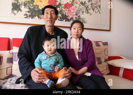 Bildnummer: 53401058  Datum: 21.09.2009  Copyright: imago/Xinhua  -- CHIFENG,  (Xinhua) -- 2.36-meters-high Chinese herdsman Bao Xishun, the previous world s tallest man, stays with his wife and son at home, in Chifeng City, north China s Inner Mongolia Autonomous Region, Sept. 21, 2009. The Guinness World Records announced on September 16 that 27-year-old turkish man Sultan Kosen, having his height validated at 2.465 metres, takes over the title of the world s tallest man from China s Bao Xishun. Kosen s record was unveiled to mark the launch of the Guinness World Records 2010 edition, now in Foto Stock