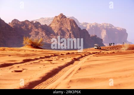 Giordania, Wadi Rum - 2 novembre 2022: Jeep safari nel deserto. Turisti e fuoristrada percorrono le dune di sabbia e il bellissimo paesaggio roccioso Foto Stock