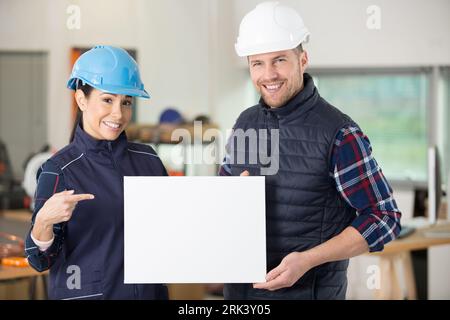 un lavoratore maschio e una donna che mostra una lavagna bianca Foto Stock