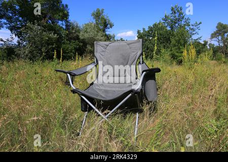 sedia da campeggio su un prato verde in una giornata di sole Foto Stock