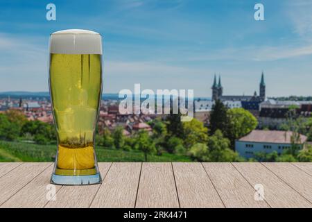 Glass of light beer on panoramic view of fields and historic old town of Bamberg, Germany Stock Photo