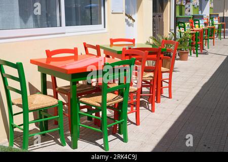 Colourful, colored wooden bistro tables and chairs in Giardini Naxos near Taormina, Sicily, Italy Stock Photo