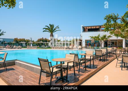 Kos, Grecia - 7 maggio 2023: Tavoli e sedie da caffè vicino alla piscina nell'hotel greco resort sull'isola di Kos. Grecia Foto Stock