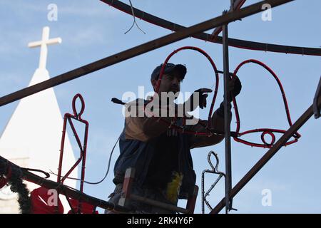 Bildnummer: 53679501  Datum: 19.12.2009  Copyright: imago/Xinhua (091220)--BETHLEHEM, Dec. 20, 2009 (Xinhua) -- A Palestinian Municipal worker decorates the main Christmas tree in the West Bank city of Beit Sahour near Bethlehem on Dec. 19, 2009, 4 days before the Christmas. Scores of Christian pilgrims are preparing to gather in the traditional birthplace of Jesus Christ at the West Bank to celebrate Christmas. (Xinhua/Luay Sababa) (yy) (5)BETHLEHEM-CHRISTMAS-TREE PUBLICATIONxNOTxINxCHN Palästina Gesellschaft Religion Christentum Weihnachten kbdig xcb 2009 quer o0 Deko, Weihnachtsdeko, Gesell Stock Photo