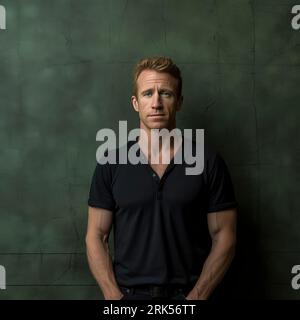 Un bel giovane con uno stile casual si trova di fronte a una parete verde vibrante Foto Stock