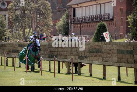 Londra Inghilterra 29 luglio 2023 cavalli sfilano intorno all'arena vestiti e pronti per una grande giostra medievale al castello di Kenilworth Foto Stock