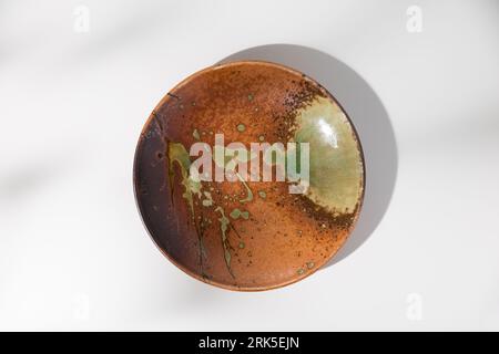 Piatto in ceramica di stile giapponese, angolo di vista dall'alto su un tavolo di legno bianco. Foto Stock