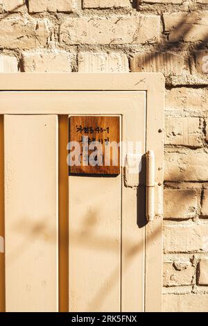 A close-up shot of a vintage sign mounted on a weathered wooden door. Foto Stock