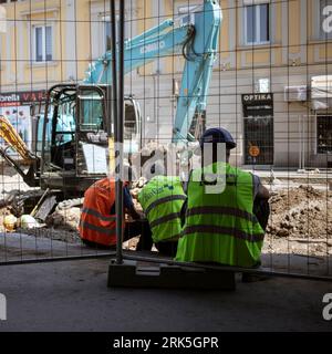 Belgrado, Serbia, 14 agosto 2023: I lavoratori che lavorano sulla strada principale (Glavna Ulica) si prendono una pausa all'ombra Foto Stock