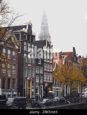 Amsterdam, Paesi Bassi - novembre 27 2022: La guglia del campanile della vecchia chiesa di Oude Kerk nel quartiere a luci rosse De Wallen di Amsterdam. Foto Stock