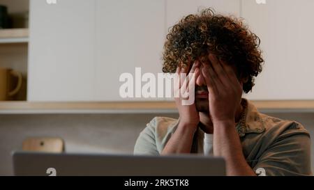 Primo piano Indiano malato stanco sonnolento uomo con capelli ricci che sfregano occhi asciutti uomo d'affari malato stanco arabo al chiuso soffre di affaticamento degli occhi disagio Foto Stock