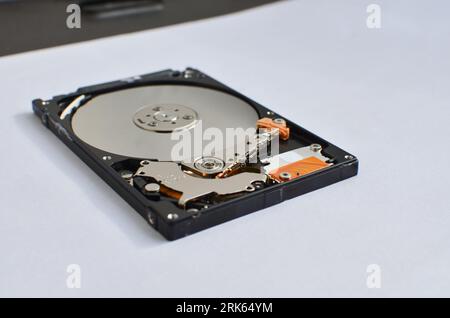 Dettaglio di un disco fisso per notebook evidenziato, a simboleggiare il supporto tecnico e il progresso tecnologico. Concetto tra assistenza tecnica e tecnologia Foto Stock