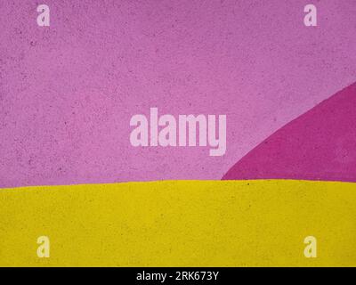 Un'immagine vibrante e accattivante di due pareti in cemento, una dipinta in una tonalità giallo brillante e l'altra in un allegro tono rosa Foto Stock