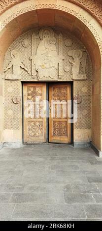 The beautifully ornate wooden doors and wall of  Saint Sarkis Cathedral in Yerevan, Armenia. Foto Stock
