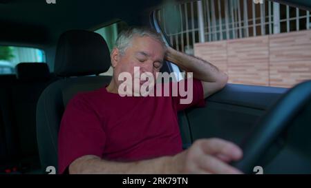 L'uomo anziano ansioso all'interno dell'abitacolo del veicolo soffre di preoccupazioni e rammarico. La persona anziana che ricorda il trauma lotta con la depressione e l'illne mentale Foto Stock