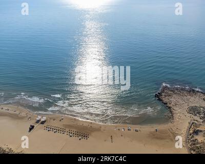 Con il riflesso del sole sulle acque turchesi nelle prime ore del mattino, spiaggia di Alcossebre, orizzontale Foto Stock