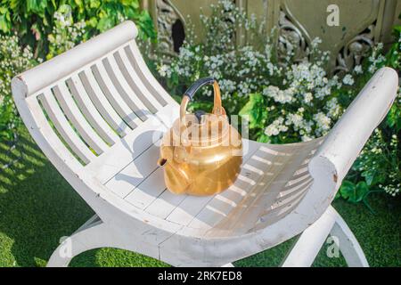 un bollitore per il te' su una sedia che viene solitamente usato durante la tradizionale doccia nuziale Foto Stock